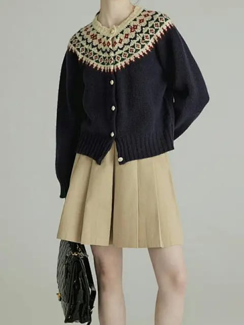 Una mujer con un cárdigan de punto azul marino con cuello estampado, una falda plisada de color beige y zapatos negros, modelo para el intercambio de ropa de AI.