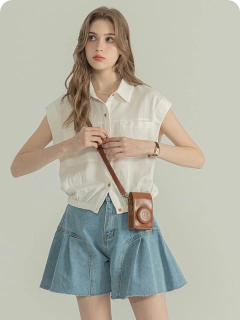 Una mujer con una camisa blanca de manga corta y una falda vaquera azul, con un bolso marrón para la cámara y zapatos informales, modelo para el intercambio de ropa de IA.