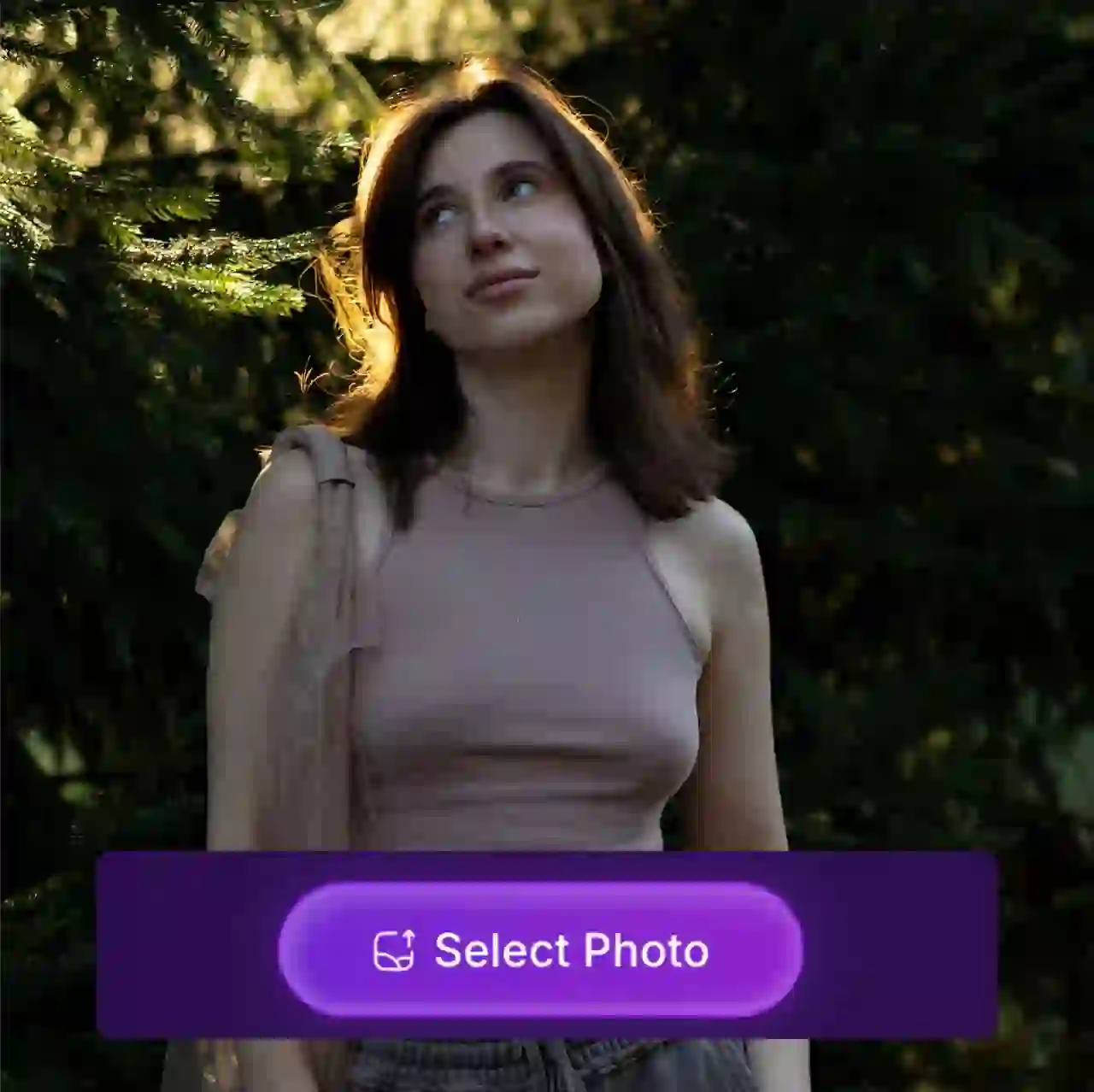 Фотография женщины в розовой майке и серых брюках, стоящей в темном лесу, и солнечный свет мягко освещает ее волосы. На изображении появляется наклейка с кнопкой «Выбрать фото», указывающая на то, что оно используется в качестве образца материала для генератора рождественских видео с использованием искусственного интеллекта.