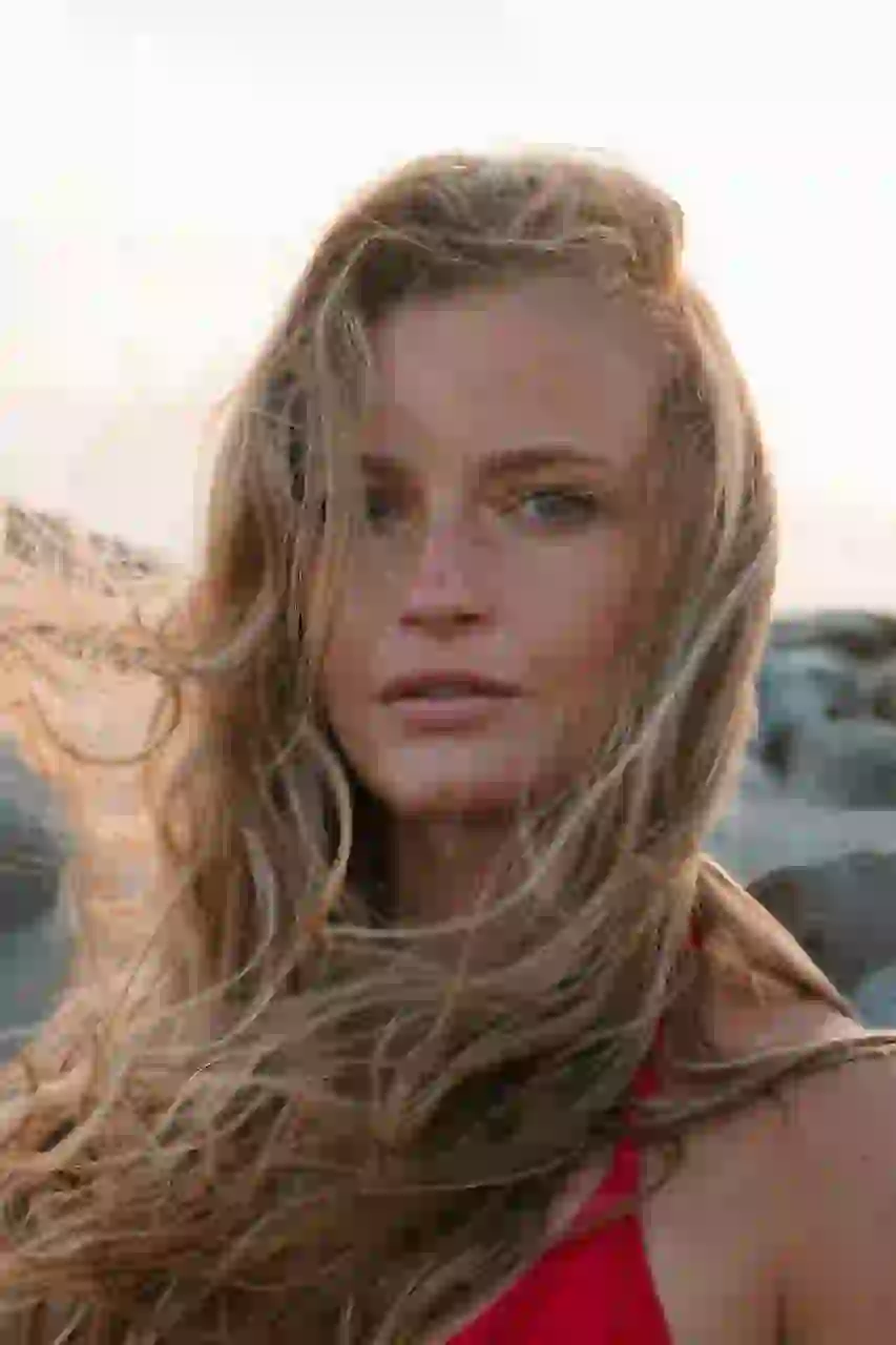 Portret blondynki, której włosy powiewają na wietrze.