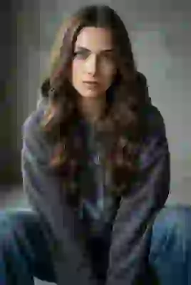 Portrait of a hippy woman with brown wavy hair in gray hoodie and jeans. Template for AI image to image.