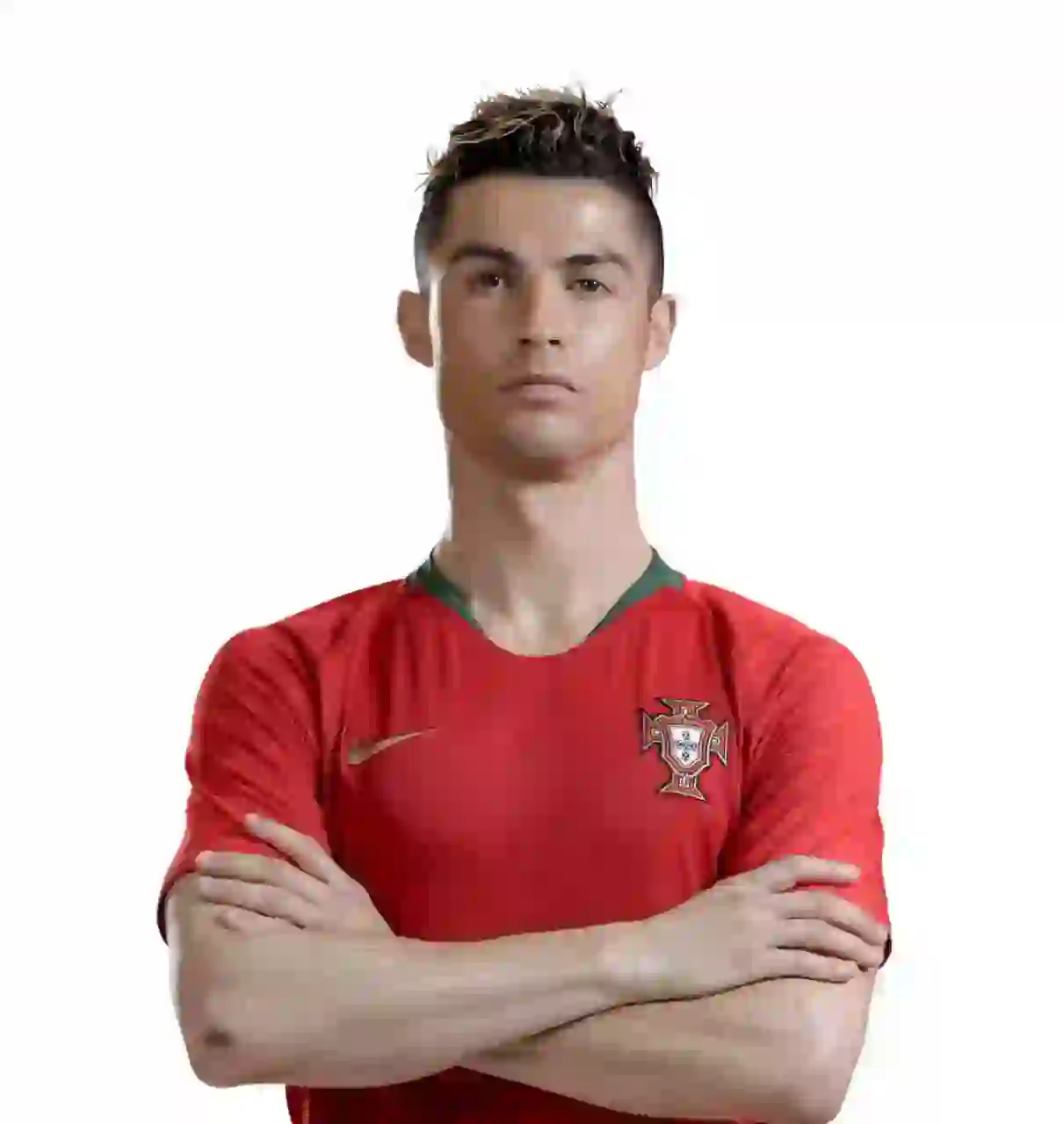 Porträtt av Cristiano Ronaldo med stylat kort mörkt hår, iklädd Portugals landslags röda hemmatröja. Armarna korsade över bröstet och stod mot en vanlig vit bakgrund med ett allvarligt uttryck.