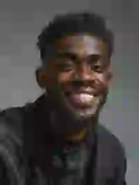 Hồ sơ của một người đàn ông da đen với mái tóc xoăn ngắn và bộ râu đang cười toe toét. Mẫu cho trình tạo ký tự South Park.