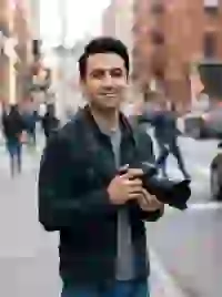 Hình ảnh do AI tạo ra về một nam nhiếp ảnh gia người Ba Tư đang đứng trên một con phố đông đúc với chiếc máy ảnh trên tay. Mẫu cho trình tạo ký tự South Park.