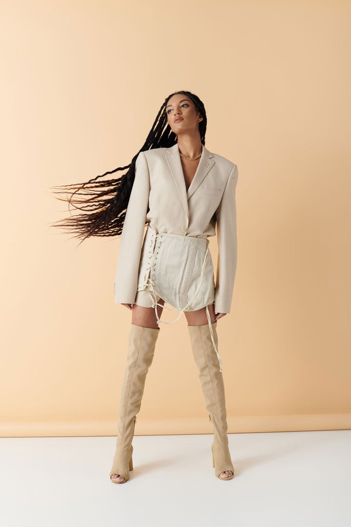 Este es un modelo femenino negro para intercambio de ropa, con cabello largo trenzado. Su cara se volvió hacia un lado, esperando un cambio de ropa con la herramienta AI.