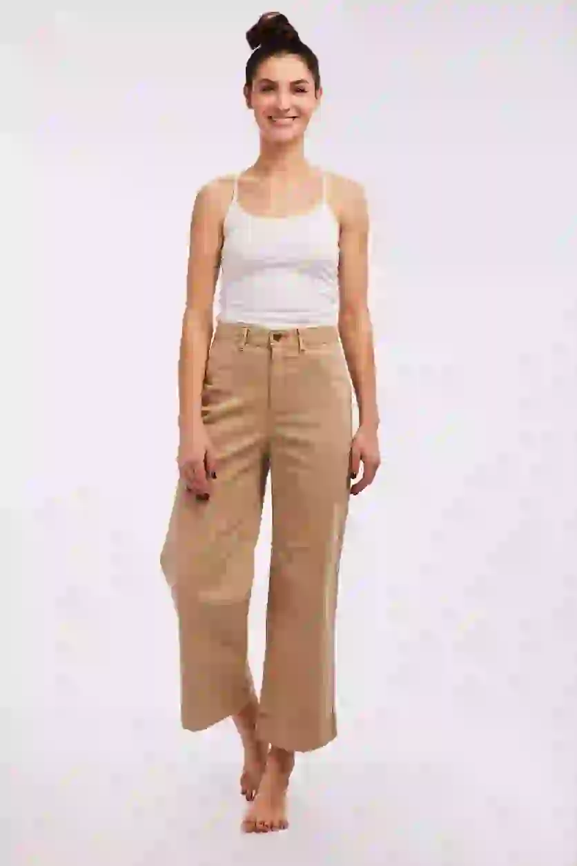 A young white model awaits the next outfit swap. With the AI clothes changer, users can quickly change her clothing.