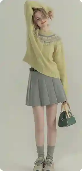 En kvinde i en lysegul striktrøje og grå plisseret nederdel poserer med en grøn håndtaske, model for AI-tøjbytte.