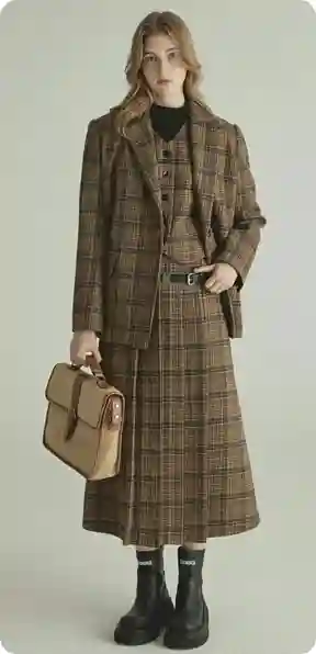 En kvinde i en lang ternet frakke, holder en beige håndtaske, iført sorte støvler, model for AI-tøjbytte.